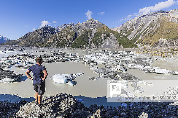 New Zealand  Oceania  South Island  Canterbury  Ben Ohau  Southern Alps (New Zealand Alps)  Mount Cook National Park  Man standing by Tasman Lake with ice floes