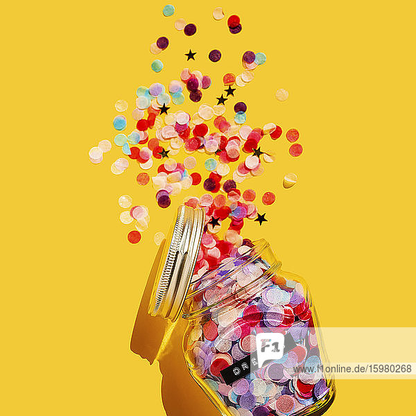 Colorful confetti spilling from glass jar