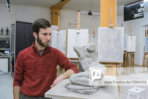 Student standing next to his sculpture