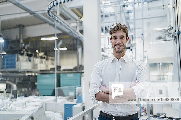 Portrait of a smiling young businessman in a factory