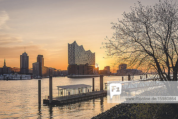 Deutschland  Hamburg  Leerer Hafen am Elbufer bei Sonnenaufgang mit Elbphilharmonie im Hintergrund