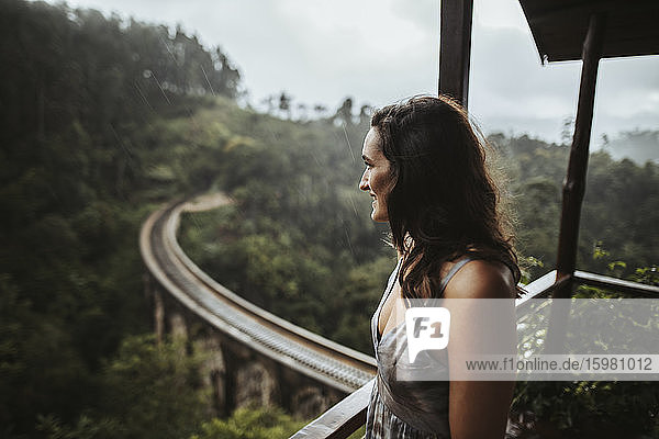 Sri Lanka  Provinz Uva  Demodara  Porträt einer erwachsenen Frau auf einem Balkon mit Blick auf die Nine Arch Bridge