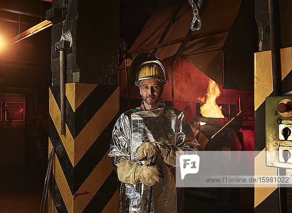 Portrait of confident worker wearing protective workwear standing in foundry