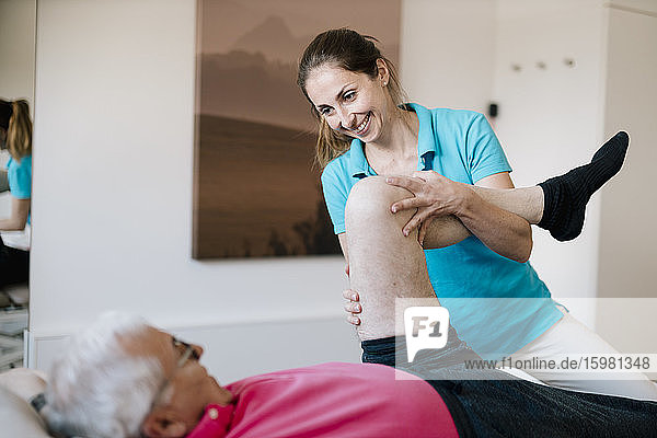 Female physiotherapist giving treatment to senior patient
