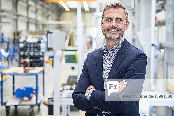Porträt eines lächelnden reifen Geschäftsmannes in einer Fabrik