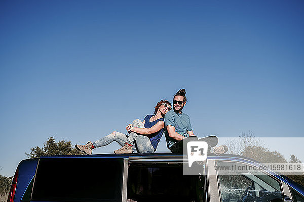 Glückliches Paar auf dem Dach eines Minivans