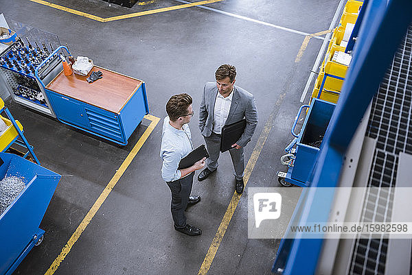 Top view of two businessmen talking in factory