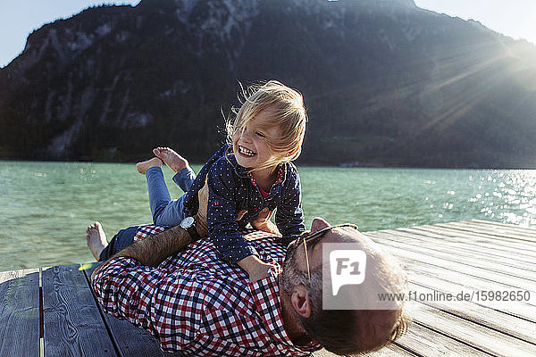 Fröhliches Mädchen und Vater auf der Uferpromenade am Achensee  Bundesland Tirol  Österreich