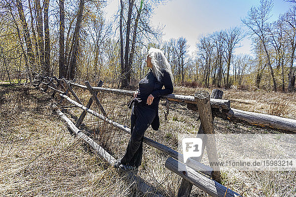 USA  Idaho  Bellevue  Seniorin entspannt sich am rustikalen Zaun