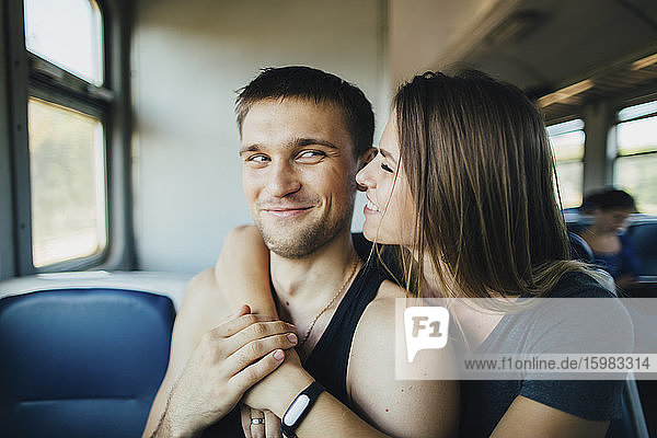 Junges Paar umarmt sich im Zug