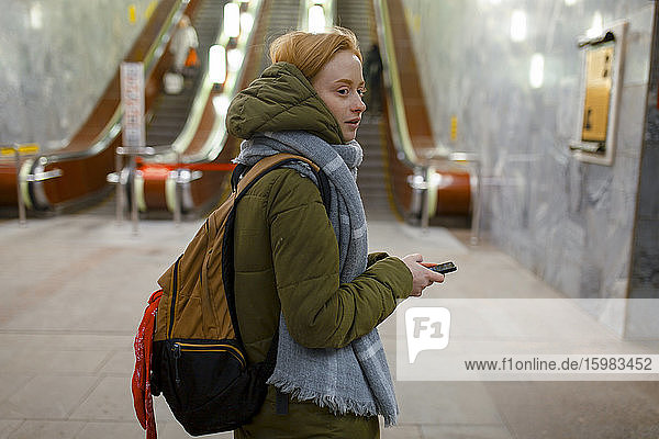 Russland  Nowosibirsk  Junge Frau steht an der Rolltreppe in der U-Bahn