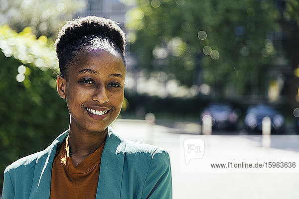 Porträt einer lächelnden jungen Geschäftsfrau im Freien
