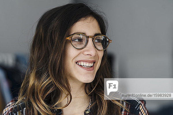 Porträt einer lachenden jungen Frau mit Brille
