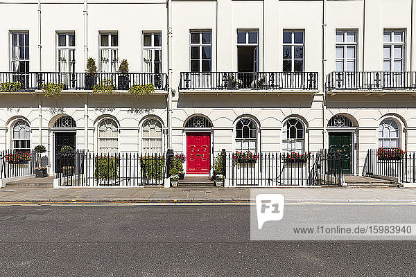 UK  London  Weißes Gebäude mit roten und schwarzen Türen in einer leeren Straße während der Ausgangssperre