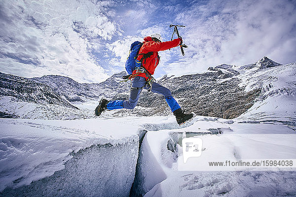 Mountaineer jumping over crevasse  Glacier Grossvendediger  Tyrol  Austria