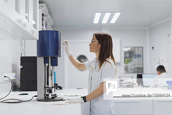 Female scientist using equipment while working at laboratory