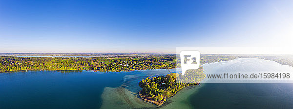 Deutschland  Bayern  Inning am Ammersee  Drohnenpanorama von klarem Himmel über dem bewaldeten Ufer der Insel Worth