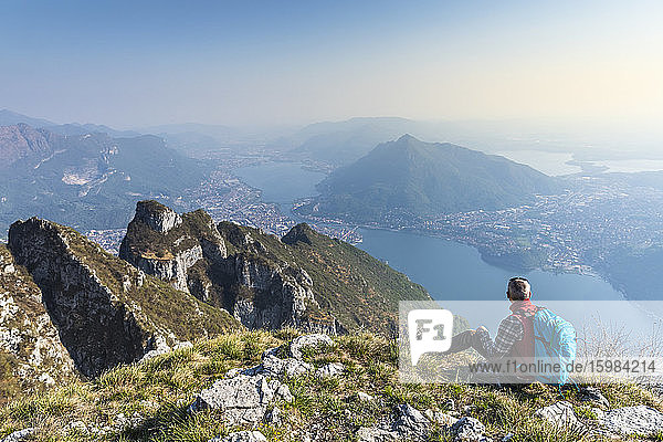 Rückansicht eines Wanderers  der auf einem Berggipfel sitzt  Orobie Alpen  Lecco  Italien