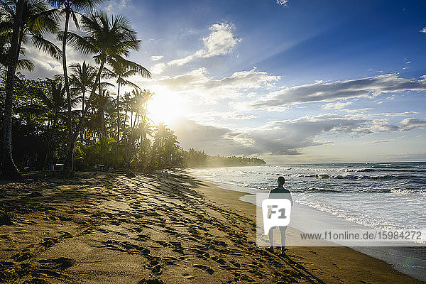 Rückansicht eines Mannes  der bei Sonnenuntergang am Strand gegen den Himmel läuft  Playa Bonita  Las Terrenas  Dominikanische Republik