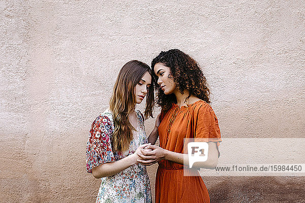 Porträt von zwei jungen Frauen  die sich an den Händen halten