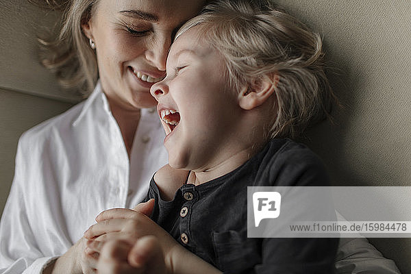 Close-up of blond boy enjoying leisure time with mother at home