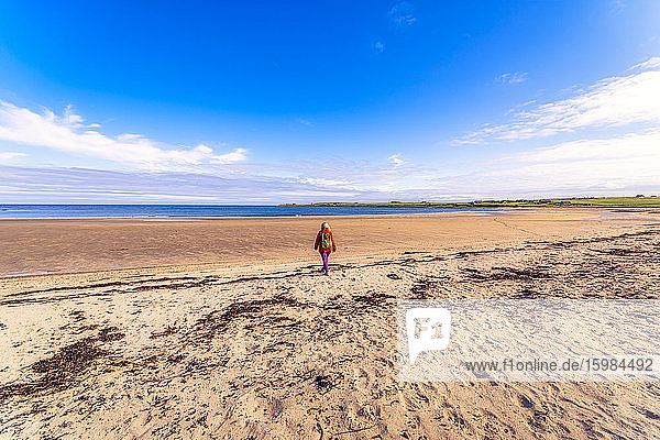 Schottland  Orkney-Inseln  South Ronaldsay  Rückansicht einer spazierenden Frau in einer Landschaft
