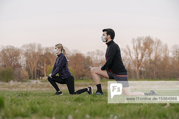 Young couple exercising at park during coronavirus pandemic