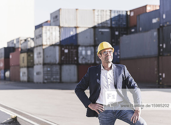 Portrait of relaxed businessman wearing safety helmet at industrial site