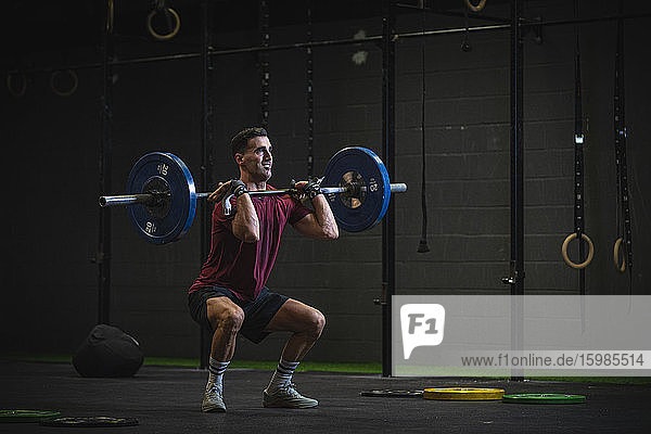 Man doing overhead squat exercise at gym