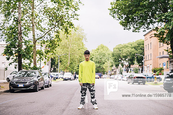 Cooler junger Mann steht auf der Straße in der Stadt