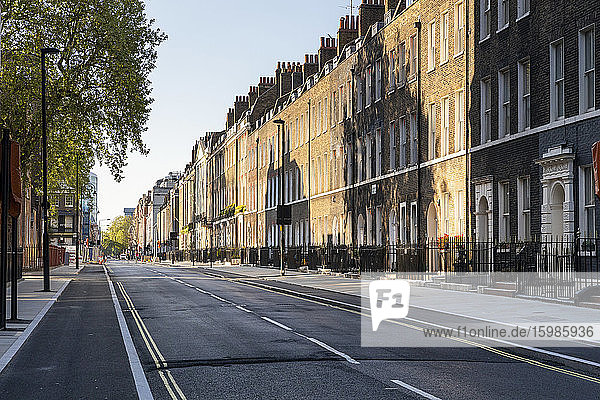 UK  London  Schatten auf Backsteingebäuden in einer leeren Straße