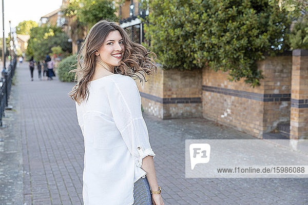 Young smiling woman looking back during stroll