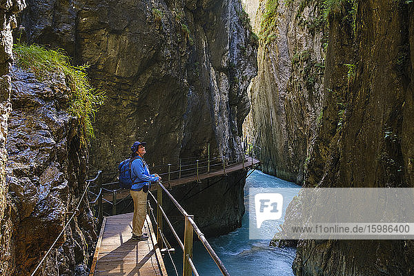 Seitenansicht einer älteren Frau auf einem Steg am Wasserfallsteig in der Leutaschklamm  Tirol  Österreich
