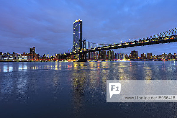 USA  New York  New York City  East River und Brooklyn Bridge in der blauen Morgendämmerung mit der Skyline von Manhattan im Hintergrund