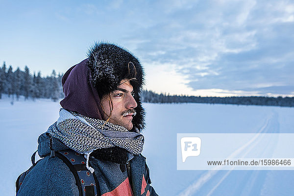 Portrait of man in winter landscape with frozen moustache  Ounasjaervi  Enontekioe  Finland