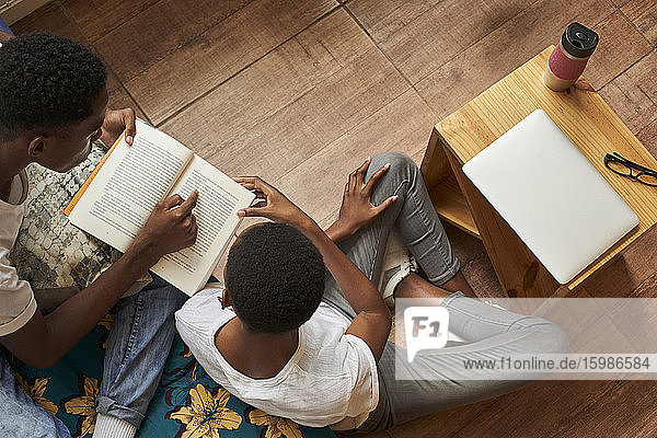 Top view of young couple reading book at home together