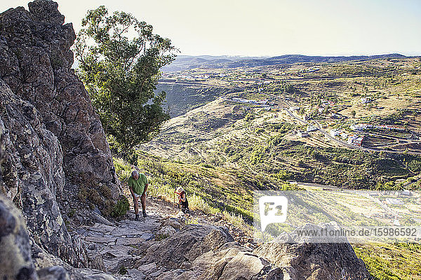 Spain  Canary Islands  La Gomera  Two hikers ascending Table Mountain with mountain village in background