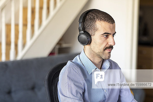 Businessman working from home  using headphones