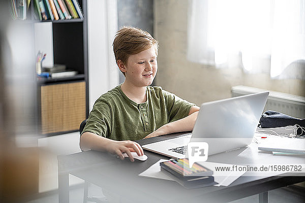 Boy during houseschooling using laptop at home