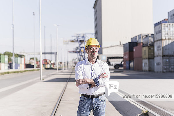 Portrait of businessman wearing safety helmet at industrial site