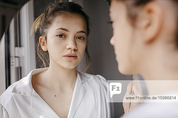 Nahaufnahme einer selbstbewussten jungen Frau  die sich zu Hause im Spiegel betrachtet