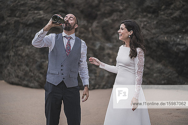 Brautpaar mit Champagner am Strand