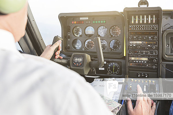 Pilot fliegt im Sportflugzeug  VFR-Karte auf dem Schoß