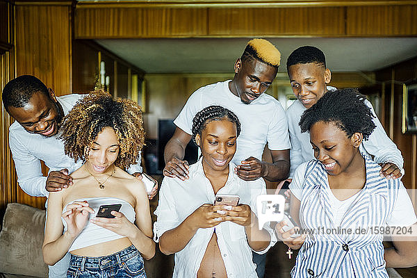 Familie und Freunde benutzen Handys zu Hause