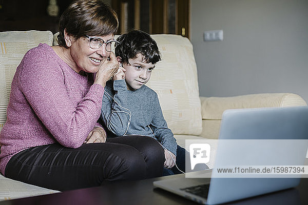 Grandmother and grandson video chatting with laptop at home