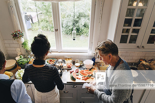 Hochwinkelansicht eines älteren Mannes und einer älteren Frau bei der Zubereitung des Abendessens an der Küchentheke