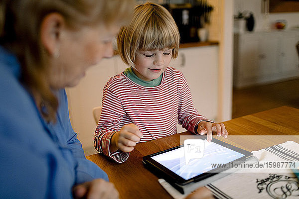 Großmutter sieht Enkel mit digitalem Tablett an