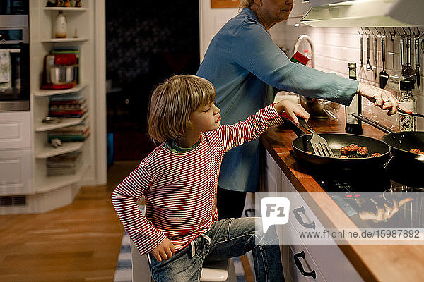 Junge hilft Großmutter beim Kochen zu Hause