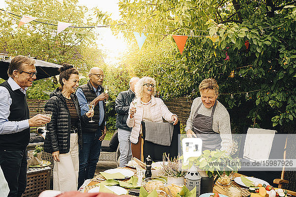 Fröhliche Seniorenfreunde genießen während der Dinnerparty im Hinterhof