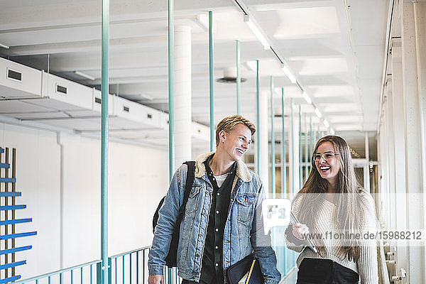 Glückliche männliche und weibliche Studenten auf dem Korridor der Universität
